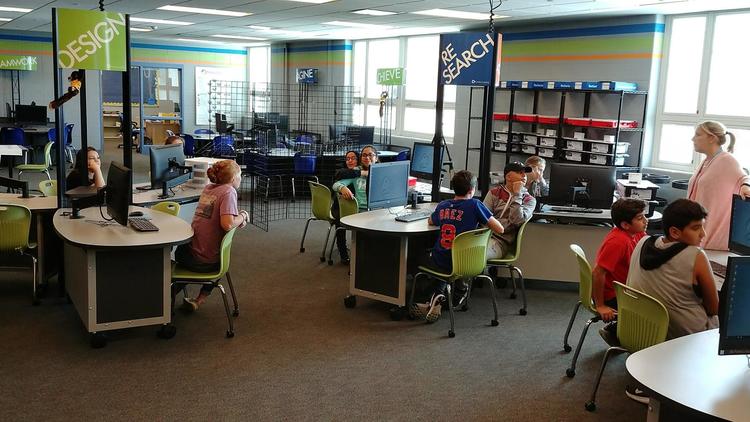 students sitting in a smart lab listening to their teacher