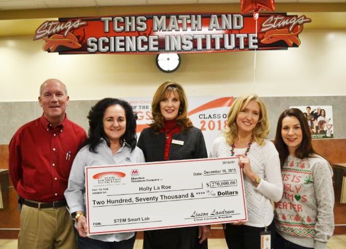 group holding up a large check under a TCHS math and science institute sign