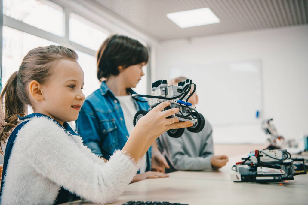 little kids sitting at class with diy robot, stem education concept