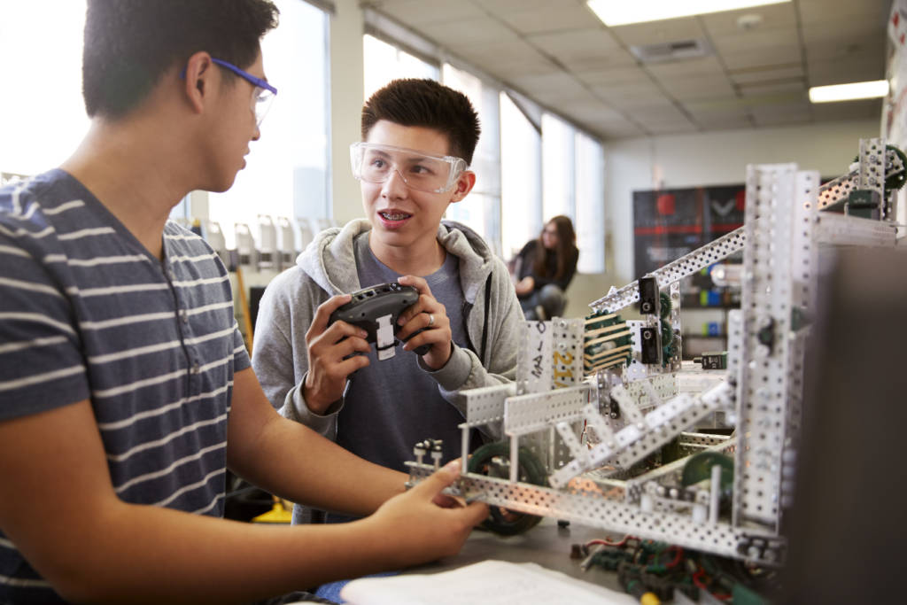 Two Male College Students Building Machine In Science Robotics Or Engineering Class