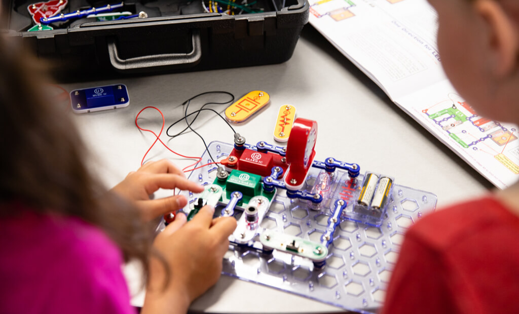 kids-working-together-on-a-circuit-board-in-class.