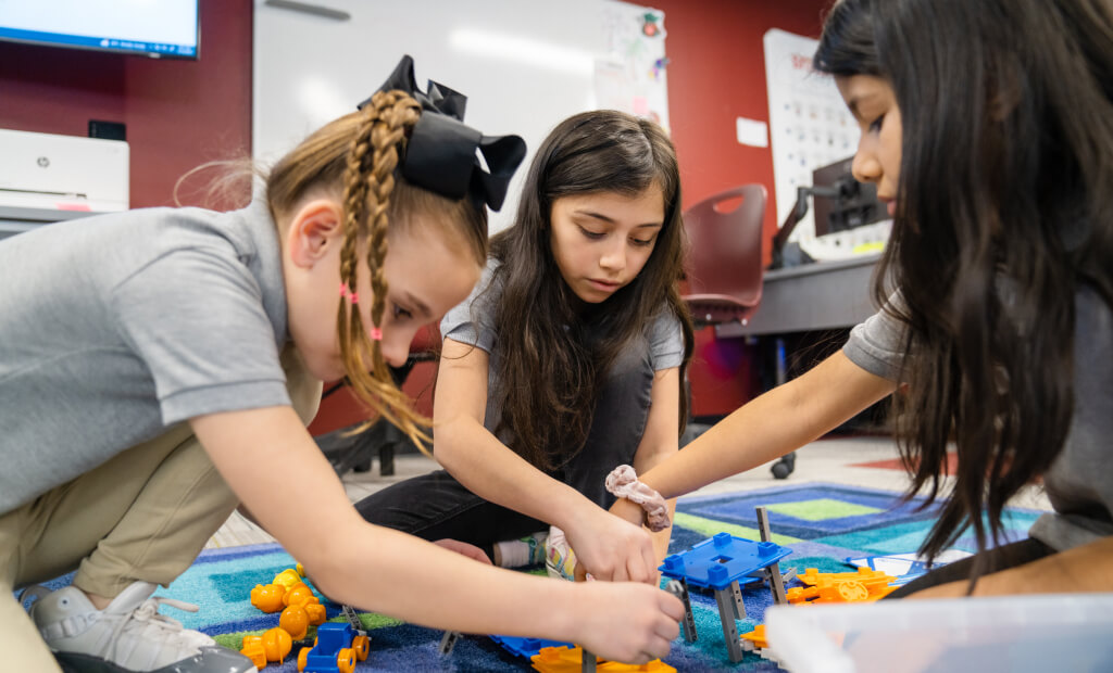 three-young-girls-putting-together-building-blocks-in-their-classroom