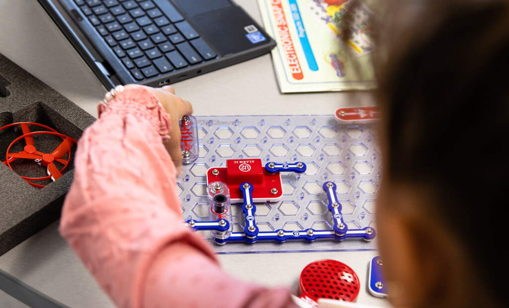 girl in a pink shirt working on a puzzle