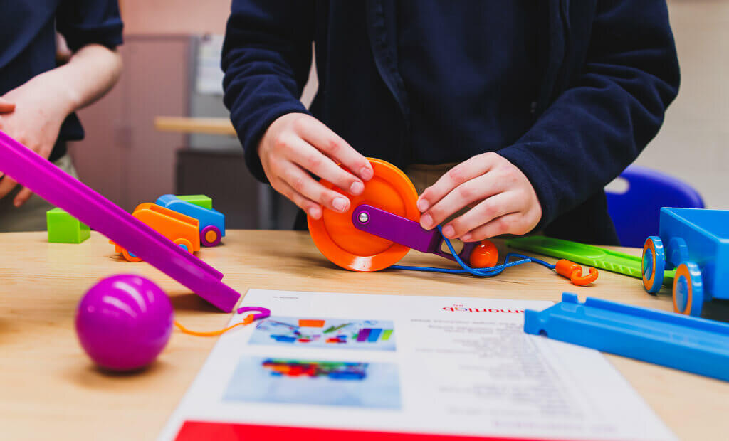 A child is engaged in play, surrounded by colorful toys on a table in a smartlab classroom setting