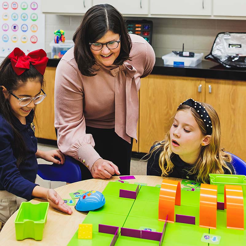 Certified facilitator coaching students on a STEM project