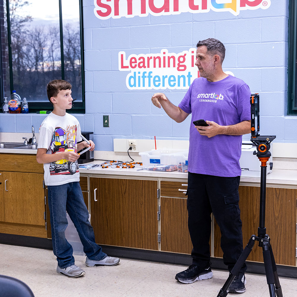 Facilitator teacher helping student understand a project in the SmartLab